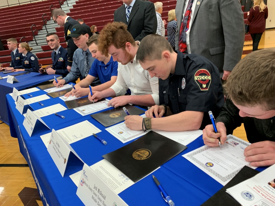 people at a table signing